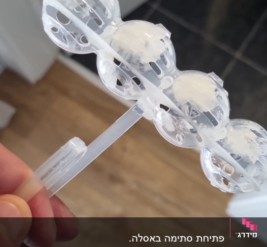 מכשיר פלסטיק שקוף עם כדורים לבנים